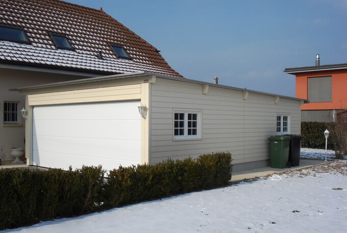 Beige Doppelgarage mit weissen Sprossenfenstern an der Seitenwand