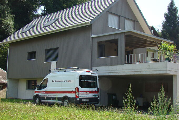 Einfamilienhaus an leichter Hanglage, dadurch wurde es auf grosser Garage mit Keller- und Technikräumen in Sichtbeton platziert